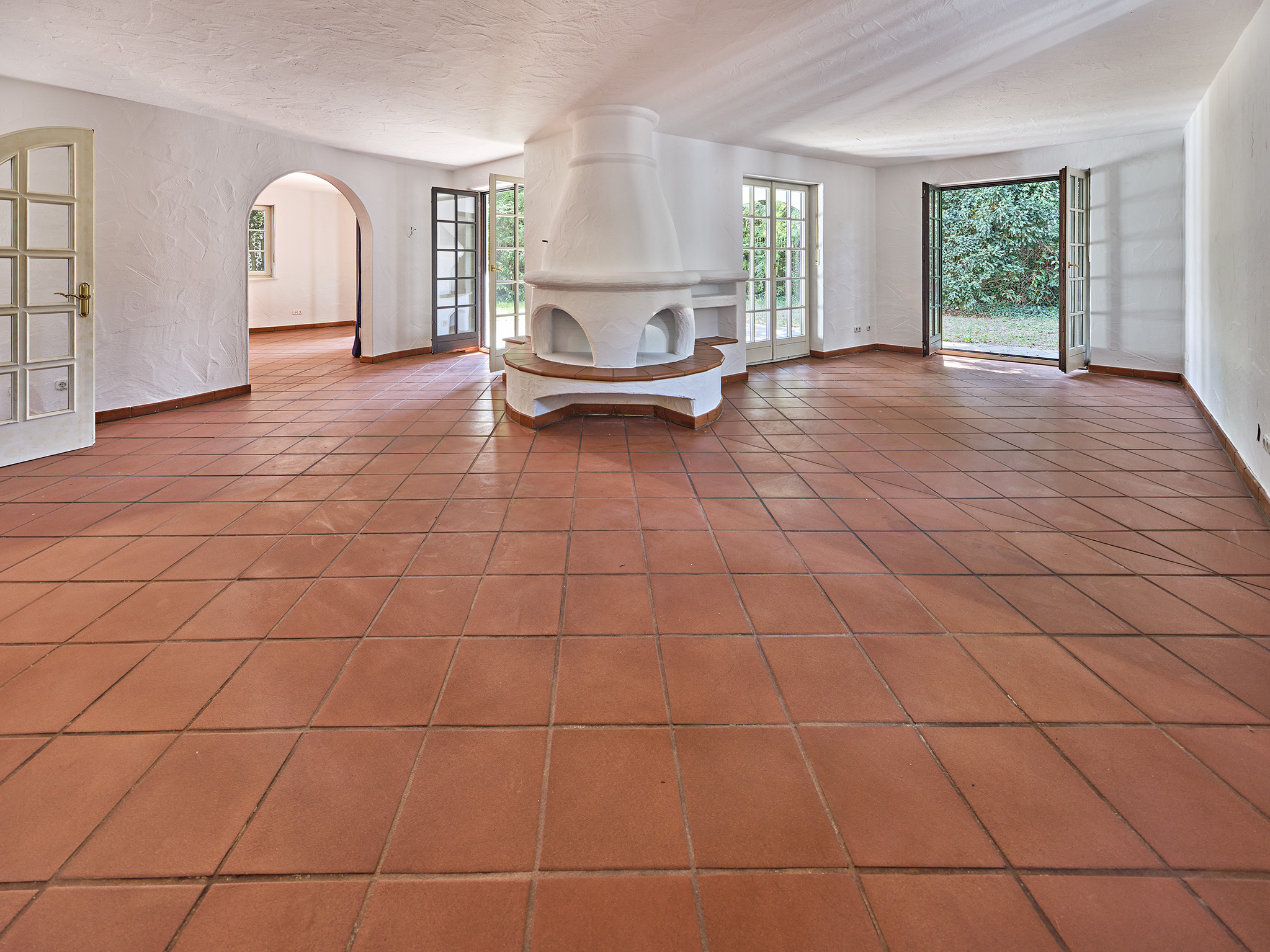 Wohnzimmer mit Innenkamin und Terrakottaboden